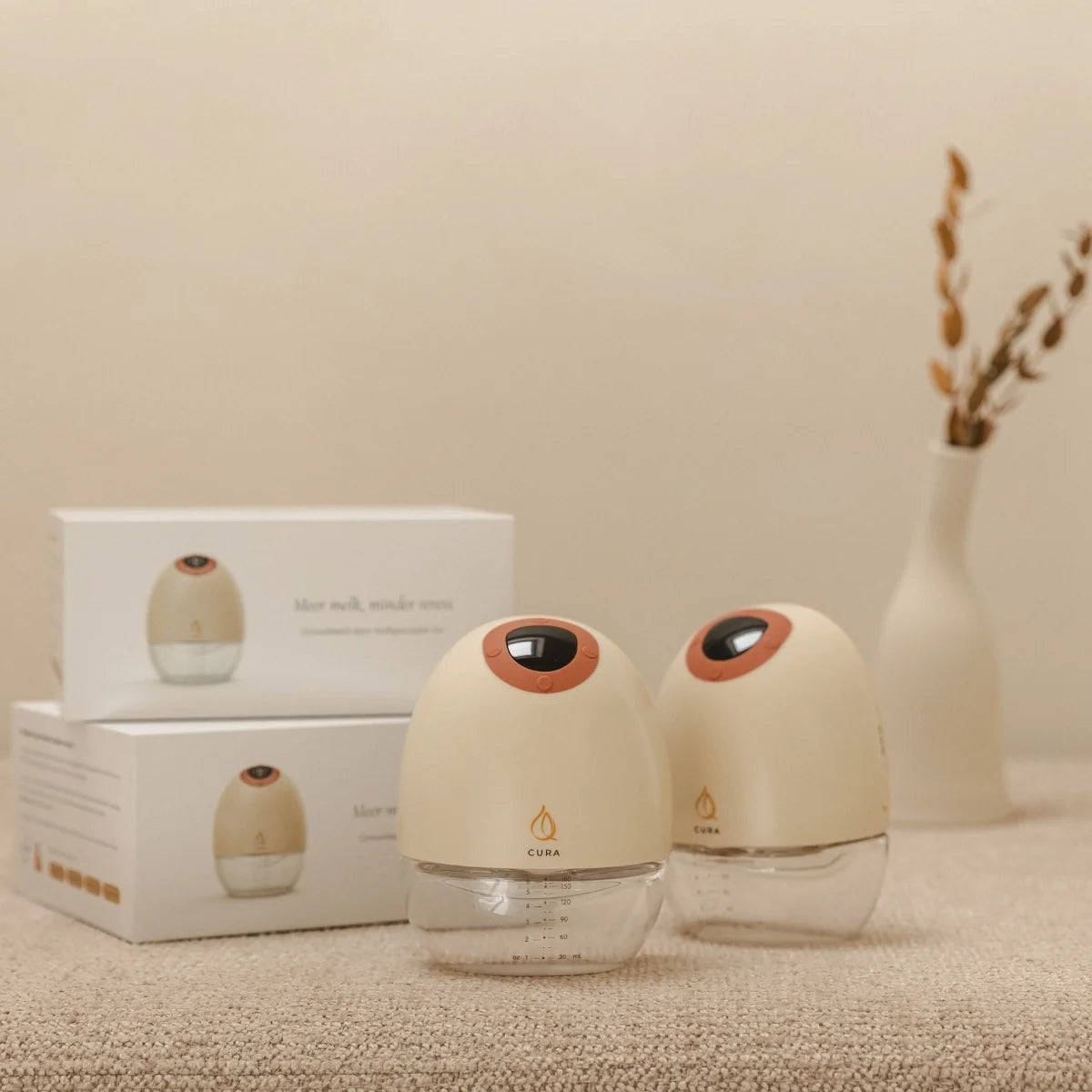 Twee Cura borstkolven voor de luxe witte productdozen in warm sfeerlicht.
